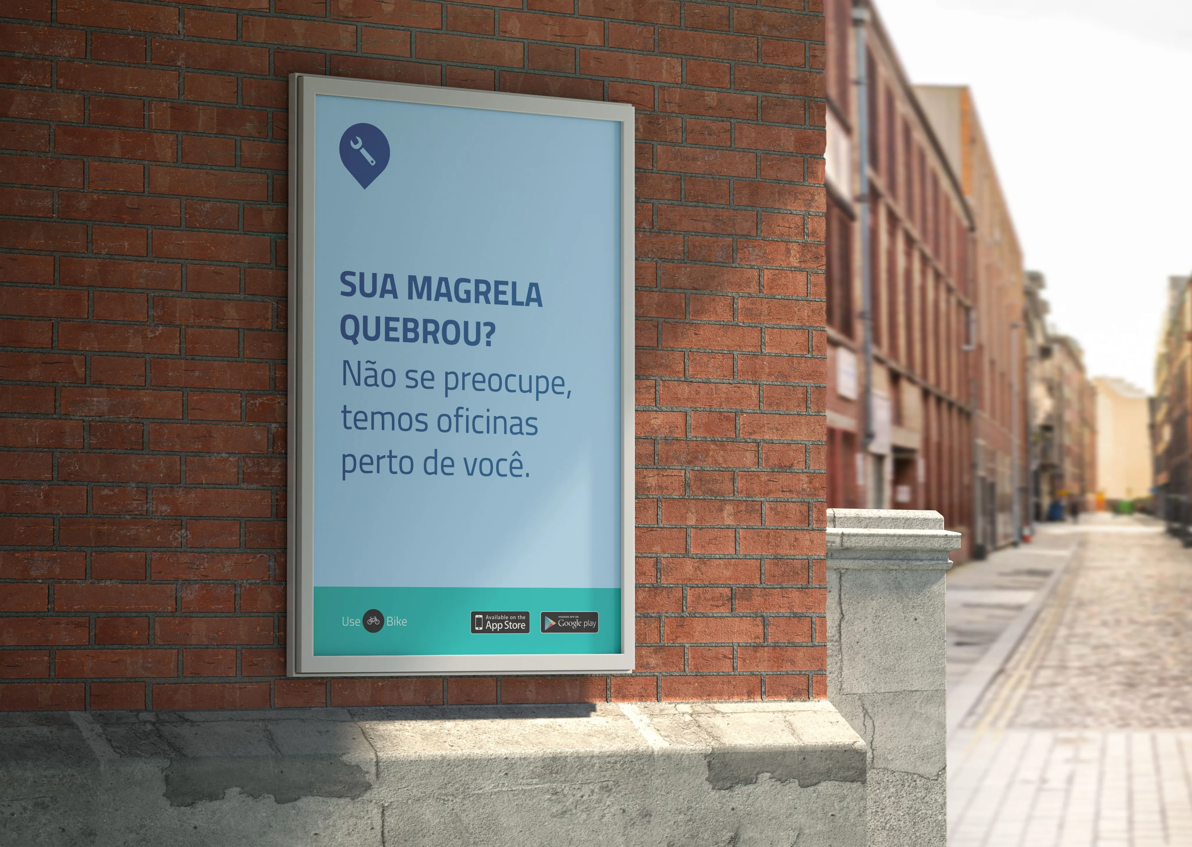 A light blue poster on a brick wall with a wrench pin icon and the copy "Sua magrela quebrou? Não se preocupe, temos oficinas perto de você."