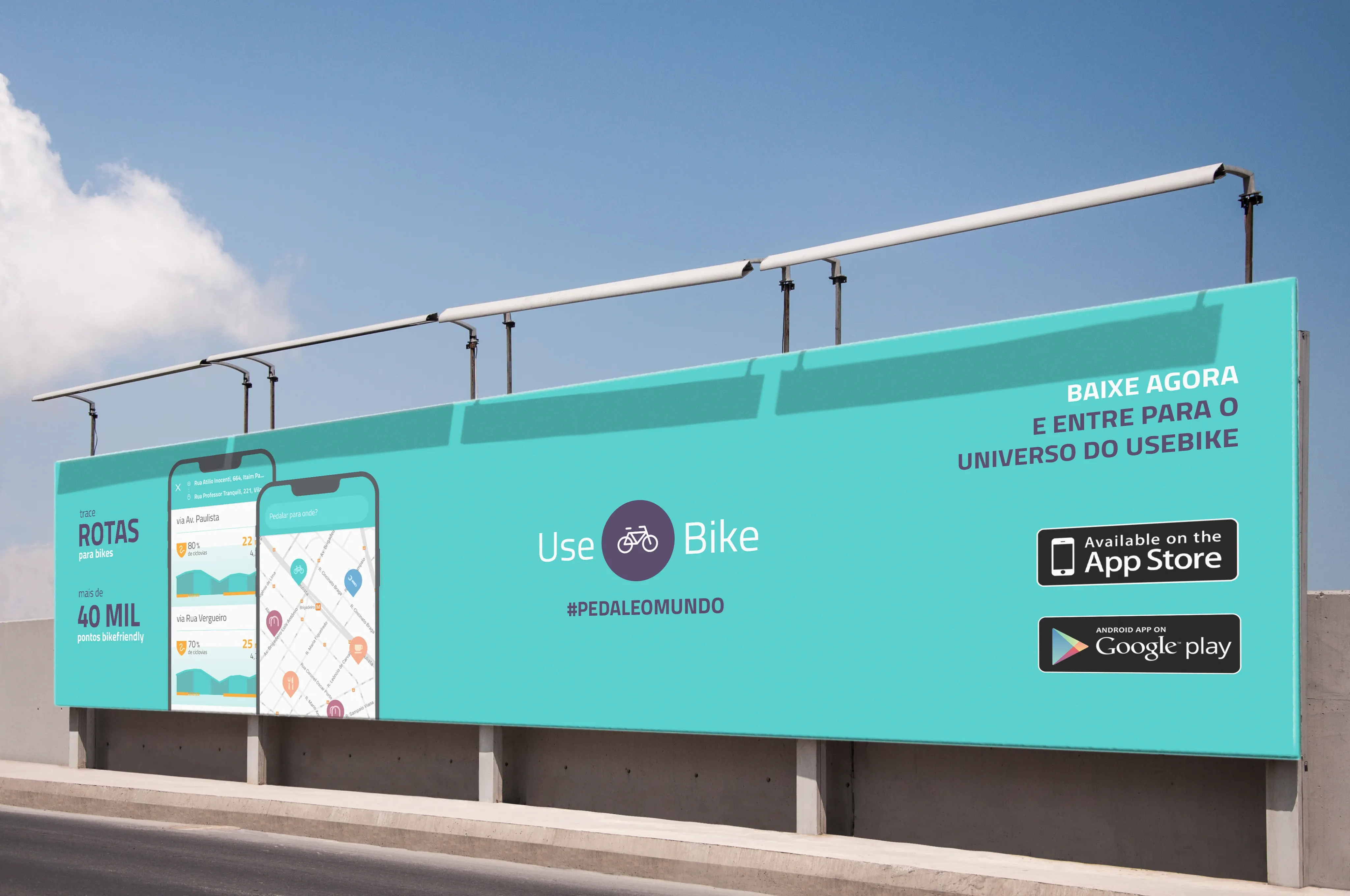 A long teal roadside billboard with two app screens, "Rotas para bikes" and "40 mil pontos bikefriendly", the UseBike logo, and App Store and Google Play badges.